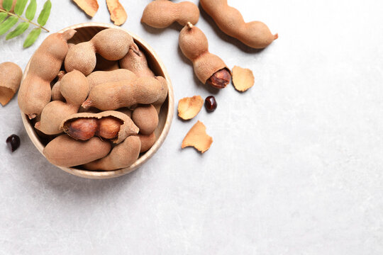 Delicious ripe tamarinds on light table, flat lay. Space for text