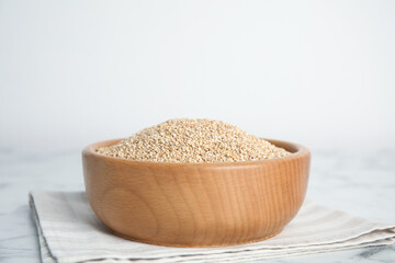 Wooden bowl with white quinoa on table. Space for text