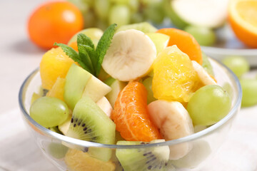 Fototapeta na wymiar Delicious fresh fruit salad in bowl on table, closeup view