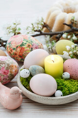 Fototapeta na wymiar Easter table decorations with eggs, moss and ceramic figurines.