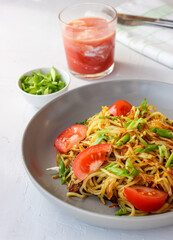 Fried potatoes in straws on a plate with green onions.