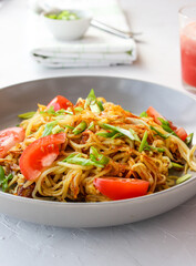 Fried potatoes in straws on a plate with green onions.