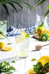 Glass of homemade lemonade on white wooden background. Vertical format.