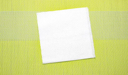 White paper napkin on a green surface. Kitchen accessories.