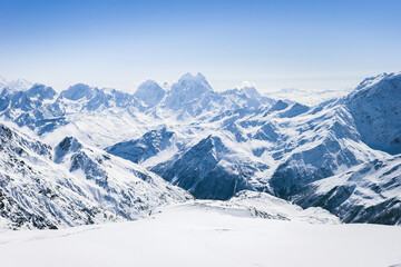 Fototapeta na wymiar Snowy winter Greater Caucasus mountains at sunny day. View from ski slope Elbrus, Kabardino-Balkaria, Russia