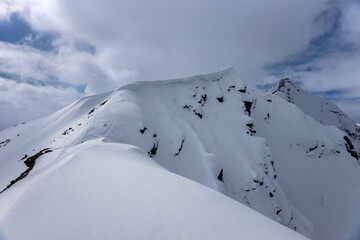 Snow cornice near Mount Cheget summit with snowboard track