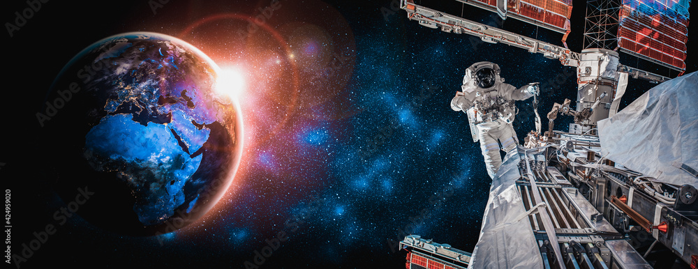 Wall mural astronaut spaceman do spacewalk while working for space station in outer space . astronaut wear full