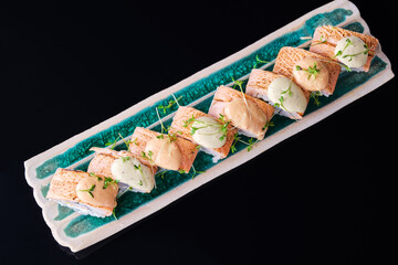 sushi rolls with fried salmon and sauce. View from above