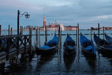 A variety of gondola just in front of Saint Mark's square and a cathedral church in the background in Venice Italy