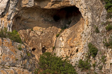 Panorama from the area of ​​Rusenski Lom Nature Park with high vertical limestone cliffs, overgrown with deciduous trees, Nisovo, Bulgaria  