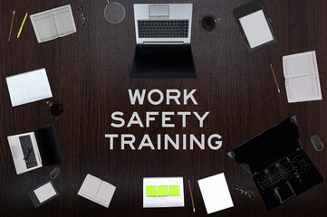 Work safety training concept. Top layout of drawings of laptops, notepads, coffee, different business stuff on table background.
