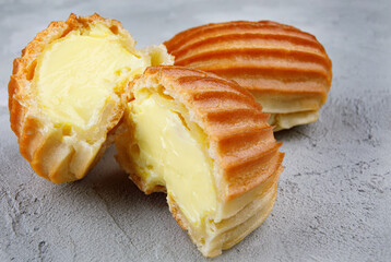 Two halves and a whole eclair on concrete .