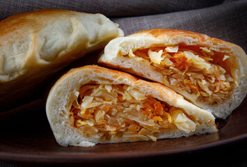 Cabbage pie on a clay plate . Russian cabbage pie .