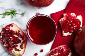 Pomegranate juice and fresh fruits on white marble table, flat lay