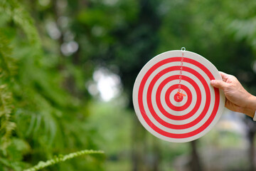 Businessman hand holding dart board with target and business growth concept