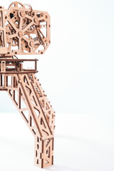 The mechanism of a toy crane made of wood on a white background