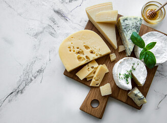 Various types of cheese, grapes and honey