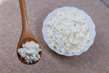 Bowl of farm cottage cheese with wooden spoon