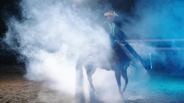 Cowboy spin trick with horse in night smoke backlight 4K