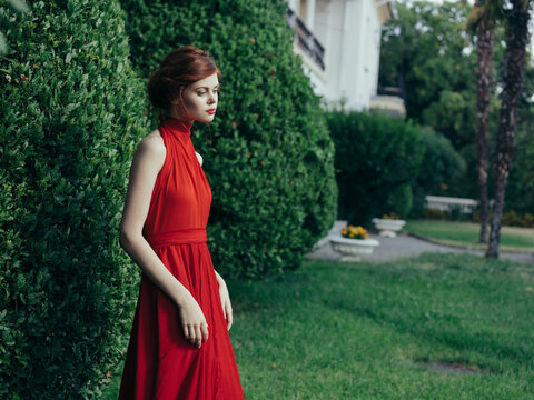 Woman in red dress luxury charm walk green bush nature gothic summer