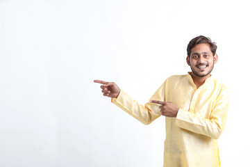 Young indian man showing direction on white background.