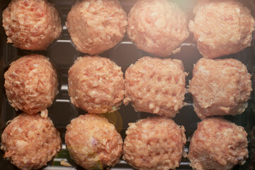 prepared raw meat balls in a black special tray.