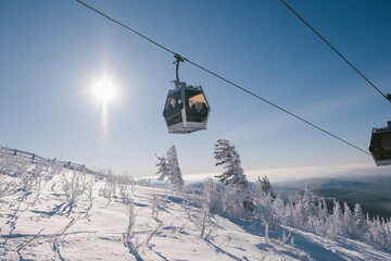 gondola ski lift in mountain ski resort, winter day, snowy spruce forest © Annatamila