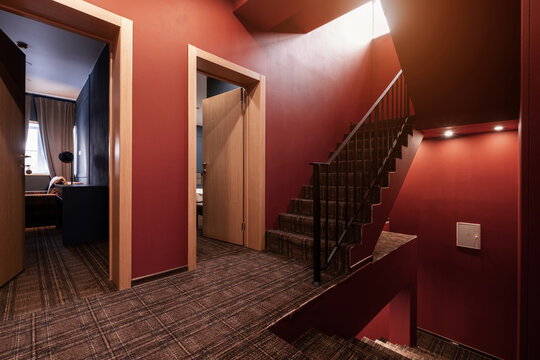 Guest house interior design, corridor with dark red walls and stairs