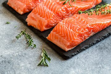 Salmon. Fresh raw salmon fish fillet with cooking ingredients, herbs and lemon. Close up. healthy food, diet or cooking concept