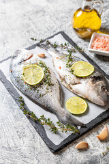 fresh raw dorado fish. dorado fish and cooking ingredients - lime, salt, oil, garlic, thyme and herbs.