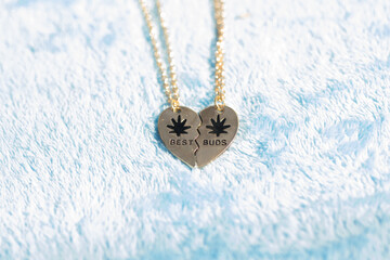 Set of best friends best buds heart necklace shoot outside in a summer day closeup. Selective...