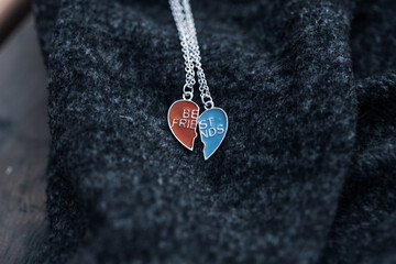 Pendant set of best friends two colors heart necklace shoot outside in a summer day closeup. Selective Focus. High quality photo