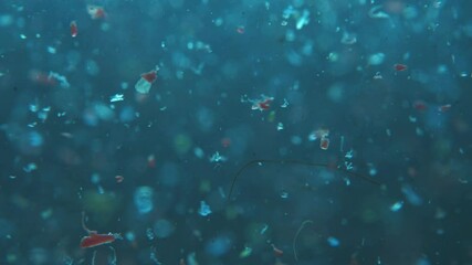 microplatics in water. plastic fragments or particles in ocean. ocean pollution by single-use plastics. environment, ecology, water, earth, slow motion