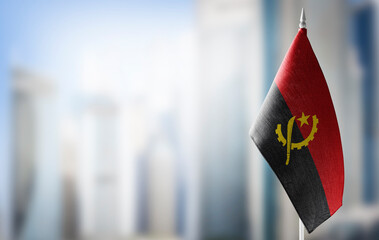 A small flag of Angola on the background of a blurred background