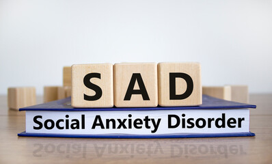 SAD, social anxiety disorder symbol. Concept words 'SAD, social anxiety disorder' on cubes on a...