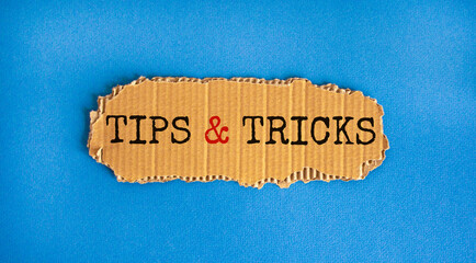 Tips and tricks symbol. Words 'Tips and tricks' on brown paper. Beautiful blue background....