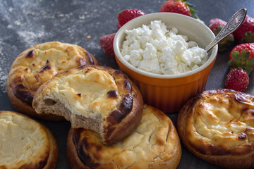 Freshly baked patties with quark. Top view photo of sweet scones with cottage cheese on a table. Homemade pastry items.