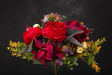 Beautiful colorful artificial flowers isolated on black background. Bunch of different roses and peony. Spring holidays or Valentine's day postcard concept