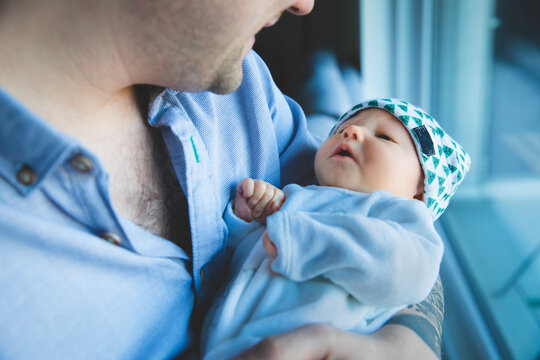 Un jeune papa tient son enfant dans ses bras