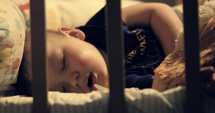 Sleeping baby. Cute baby sleeps in his crib at night under warm lamp light. Close-up