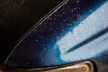 Angle of car fender above the headlight in water drops after rain