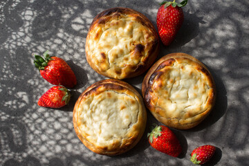Round scones with cottage cheese on a table. Russian homemade pastry items. Sweet buns top view...