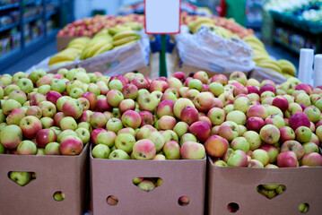 Boxes of apples on the shelves in the supermarket.