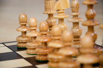 Chess board game, white wooden chess pieces. White pawn in focus.