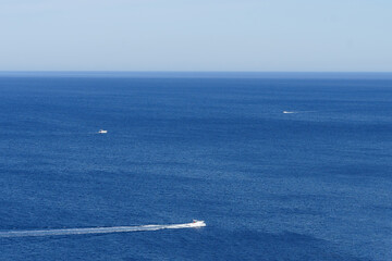 Blue Mediterranian sea view from the west coast of Minorca, Balearic Islands, Spain, with 3 boats crossing