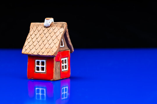 Miniature red house on a dark background. The concept of buying a property. High quality photo