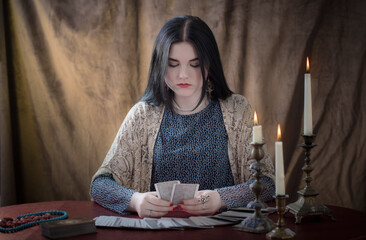 young girl guessing with tarot cards on  brown  background