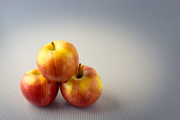 Three ripe red and fresh apples close-up. Separate against a light background.