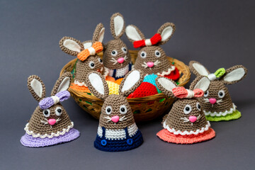 Homemade Amigurumi egg warmers crocheted from wool. In different scenes with a white and gray background and on a dining table.