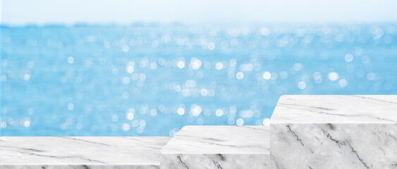 Empty white pedestal step marble table with blur sea bokeh banner background Mockup template for...